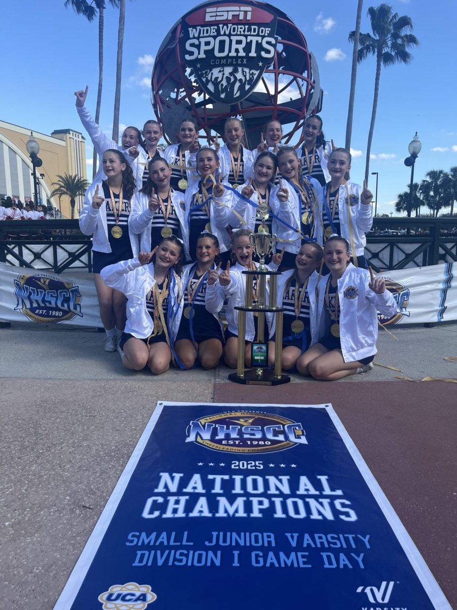 The Prior Lake junior varsity cheer team poses with their championship banner at the UCA National High School Cheer Championships in Orlando in February 2025. Submitted photo / PLHS Cheer Boosters