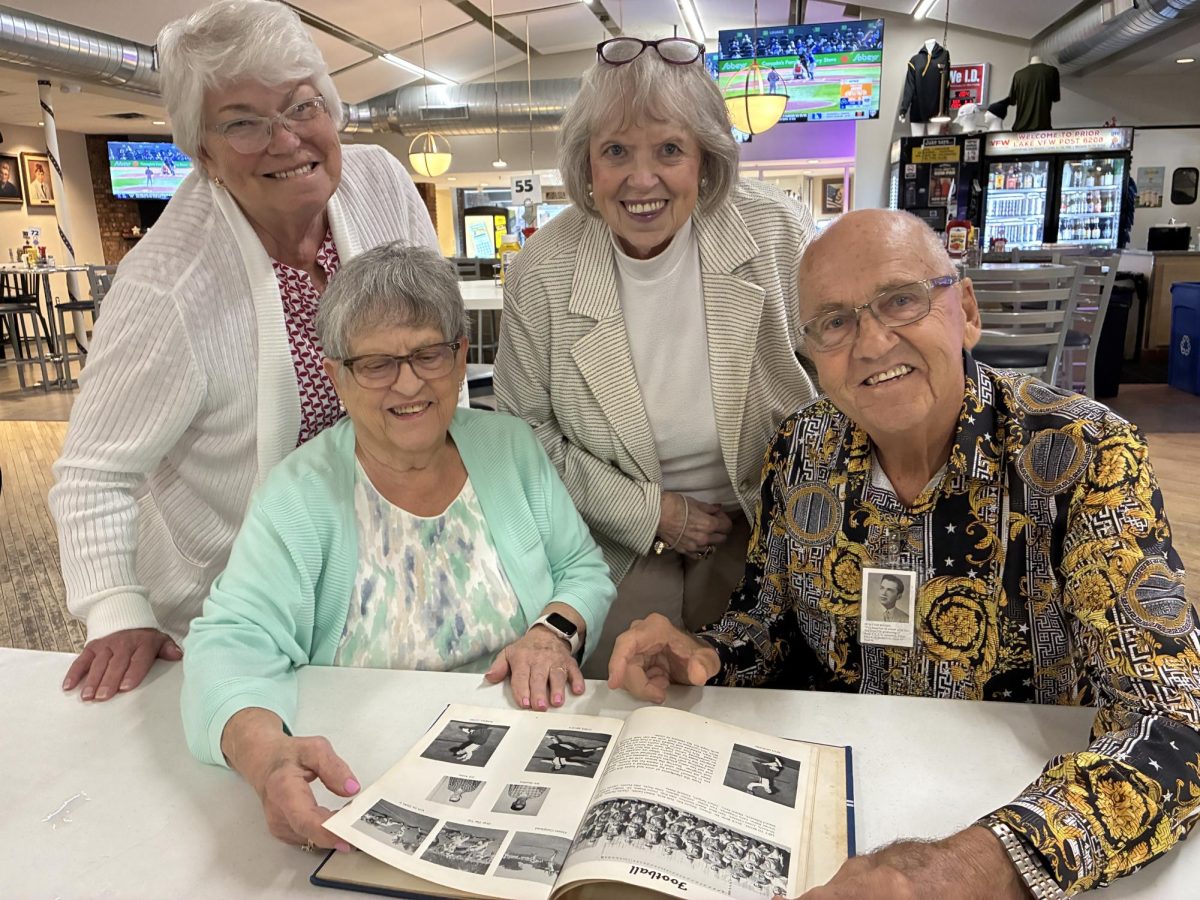 From left to right are Mary Lou Lannon, Ramona Hennen, Sandy Notermann and DuWayne Boudin, who page through their senior class yearbook during the Sept. 11 reunion.