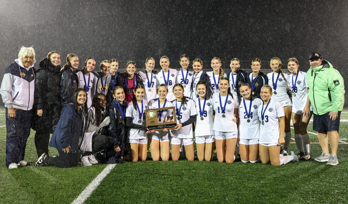 The Lakers celebrate their section championship in the rain after the big win in Chanhassen. (Caty Mawing Photography)
