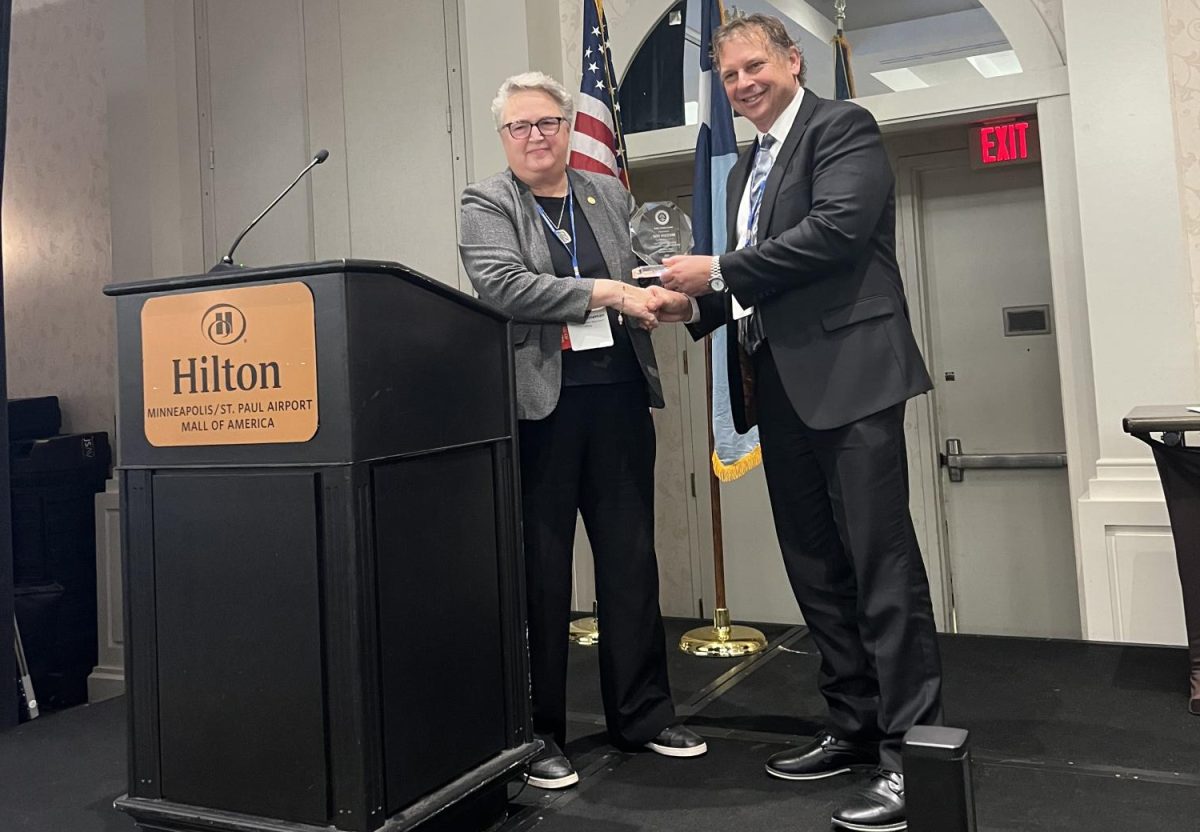 Scott County Attorney Ron Hocevar (right) accepted the Public Service Award on Dec. 3 from MCAA president Karin Sonneman.
