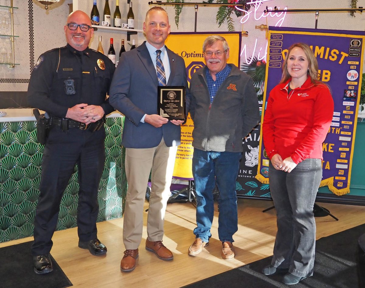 Prior Lake Police Detective Chris Schaefer was congratulated by Police Chief Liam Duggan (left), Optimist Scott Carlson and PLSOC president Anita Drentlaw.